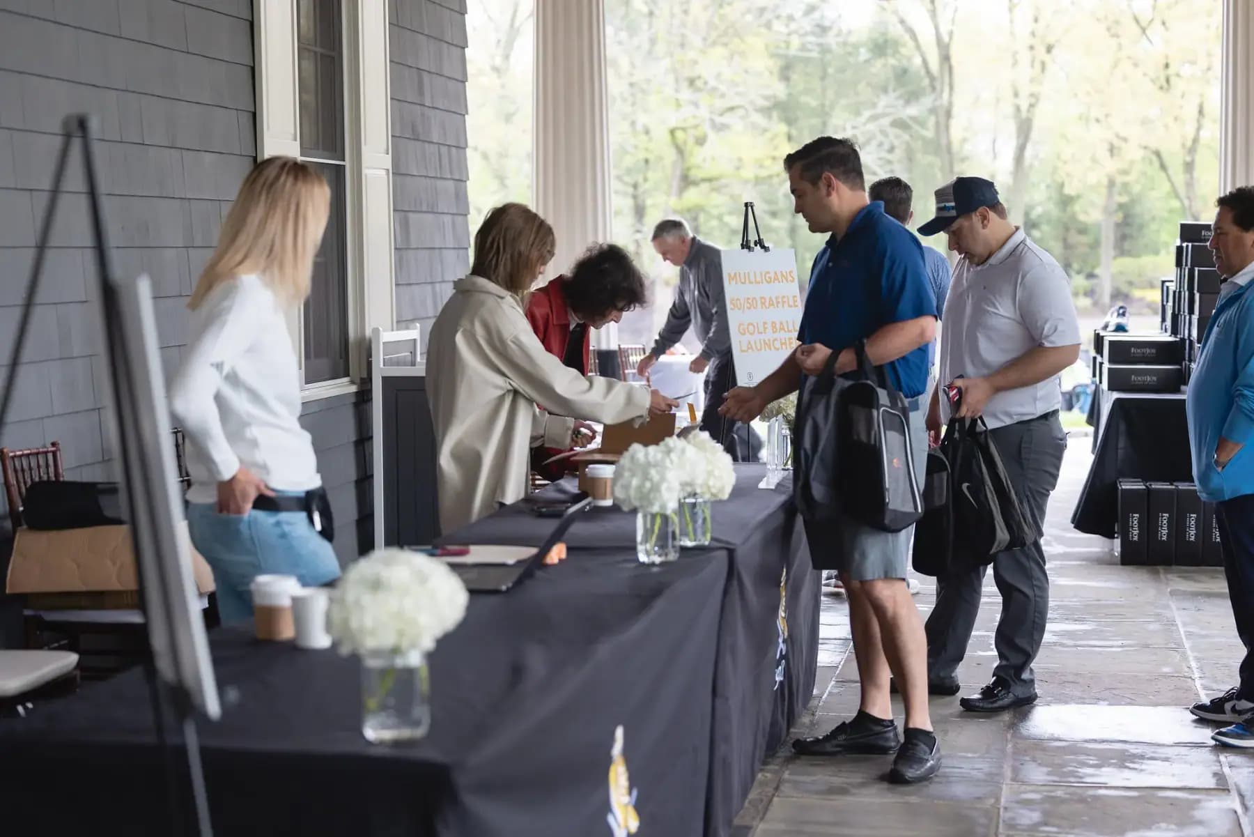 Guests checking in at the registration table on the clubhouse porch