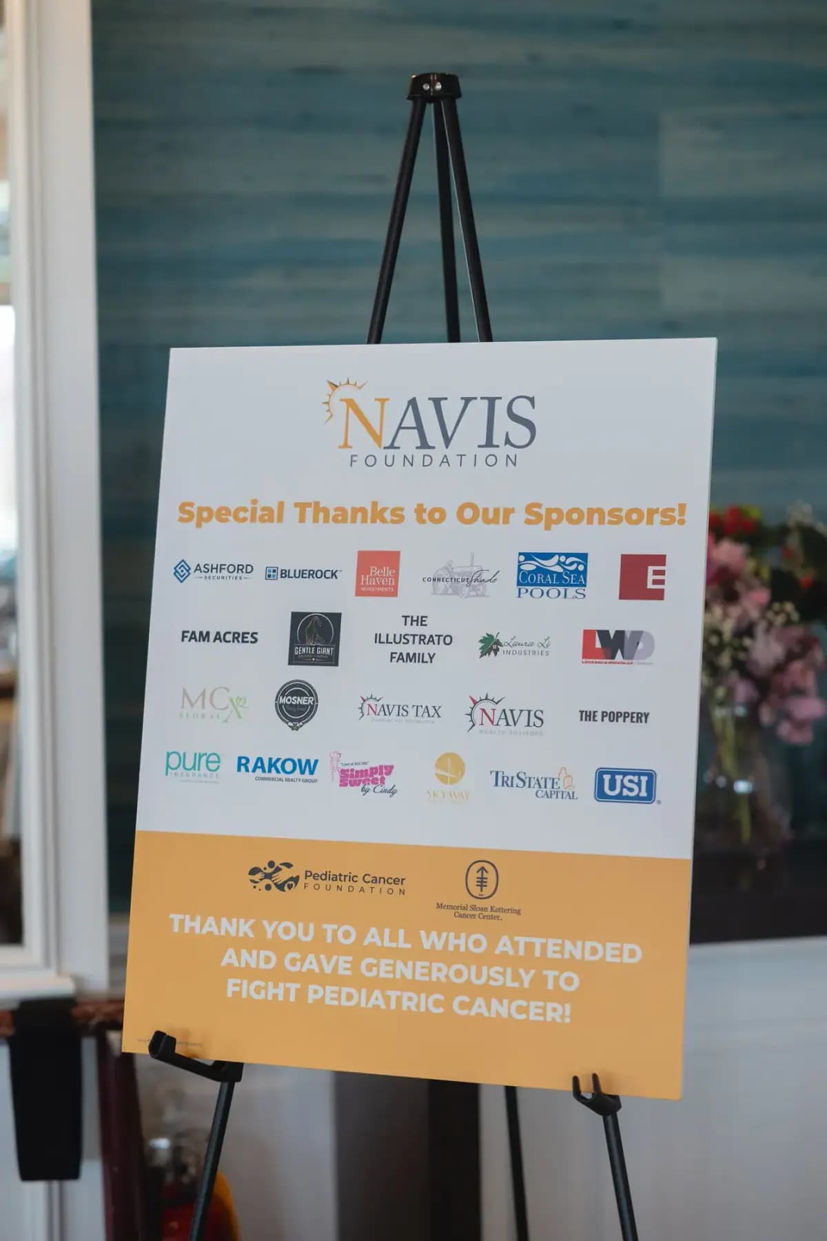 Navis Foundation sign thanking sponsors, with sponsor logos, on an easel