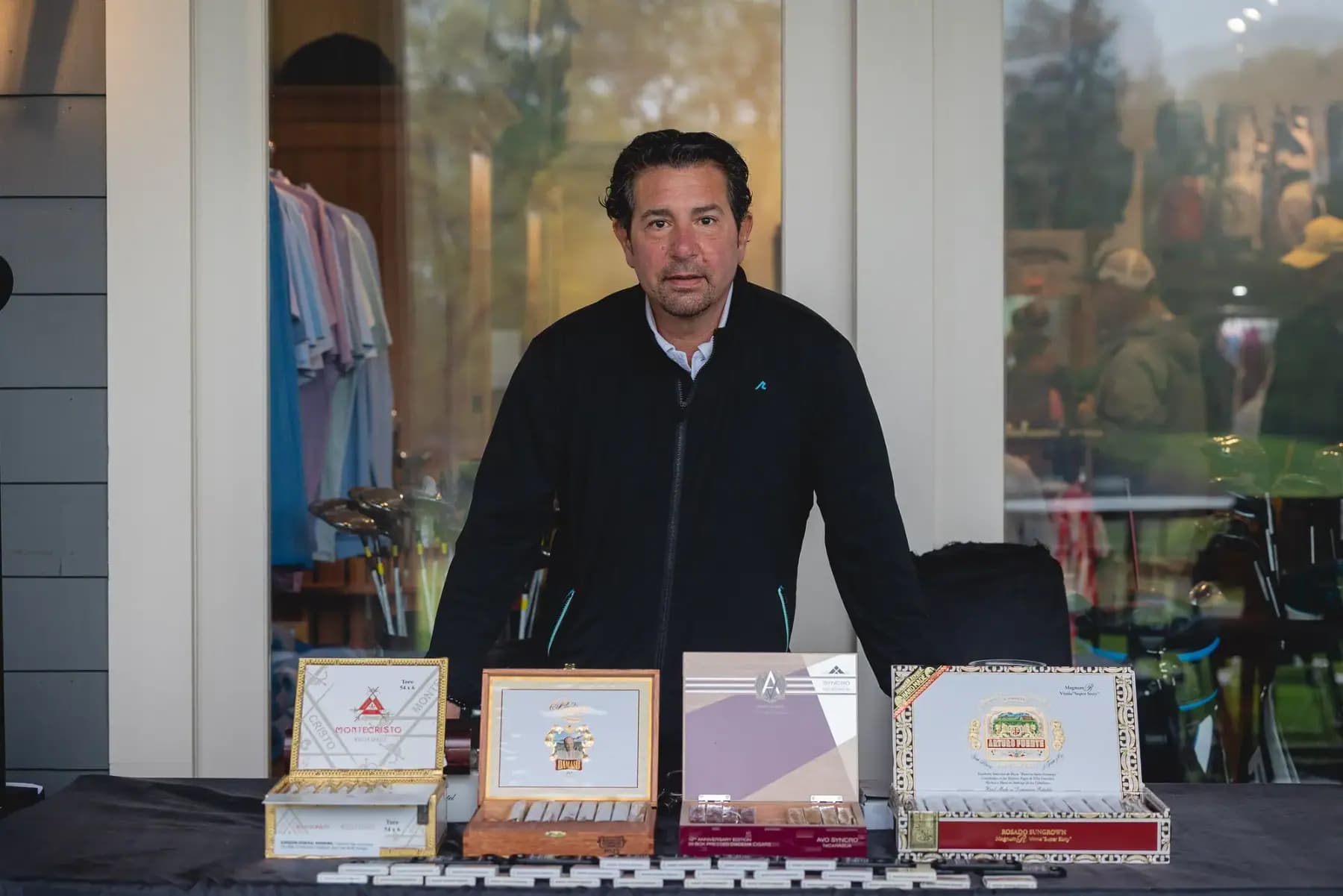 Man standing behind a display of cigar boxes