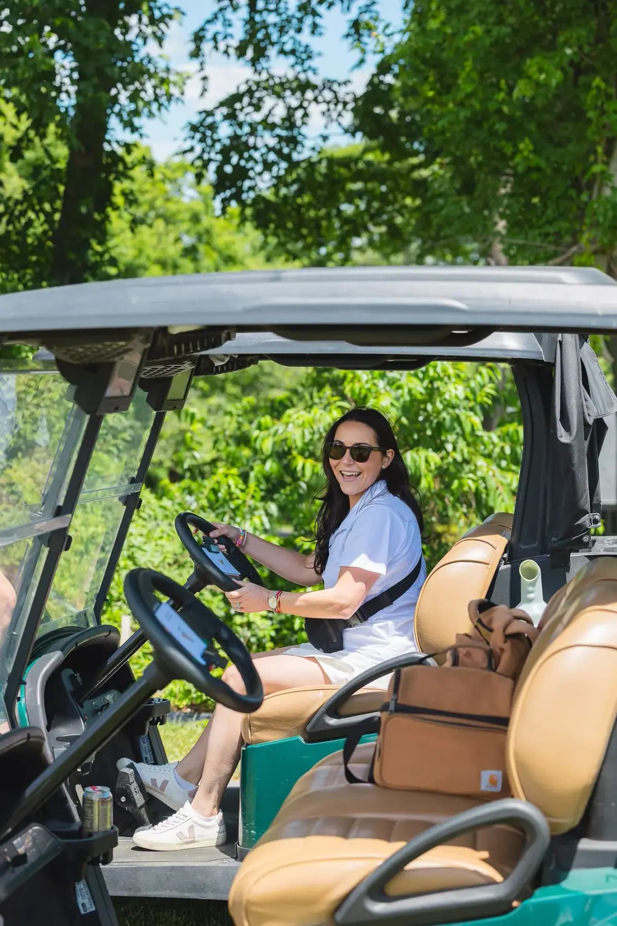 Smiling woman seated at the wheel of a golf cart