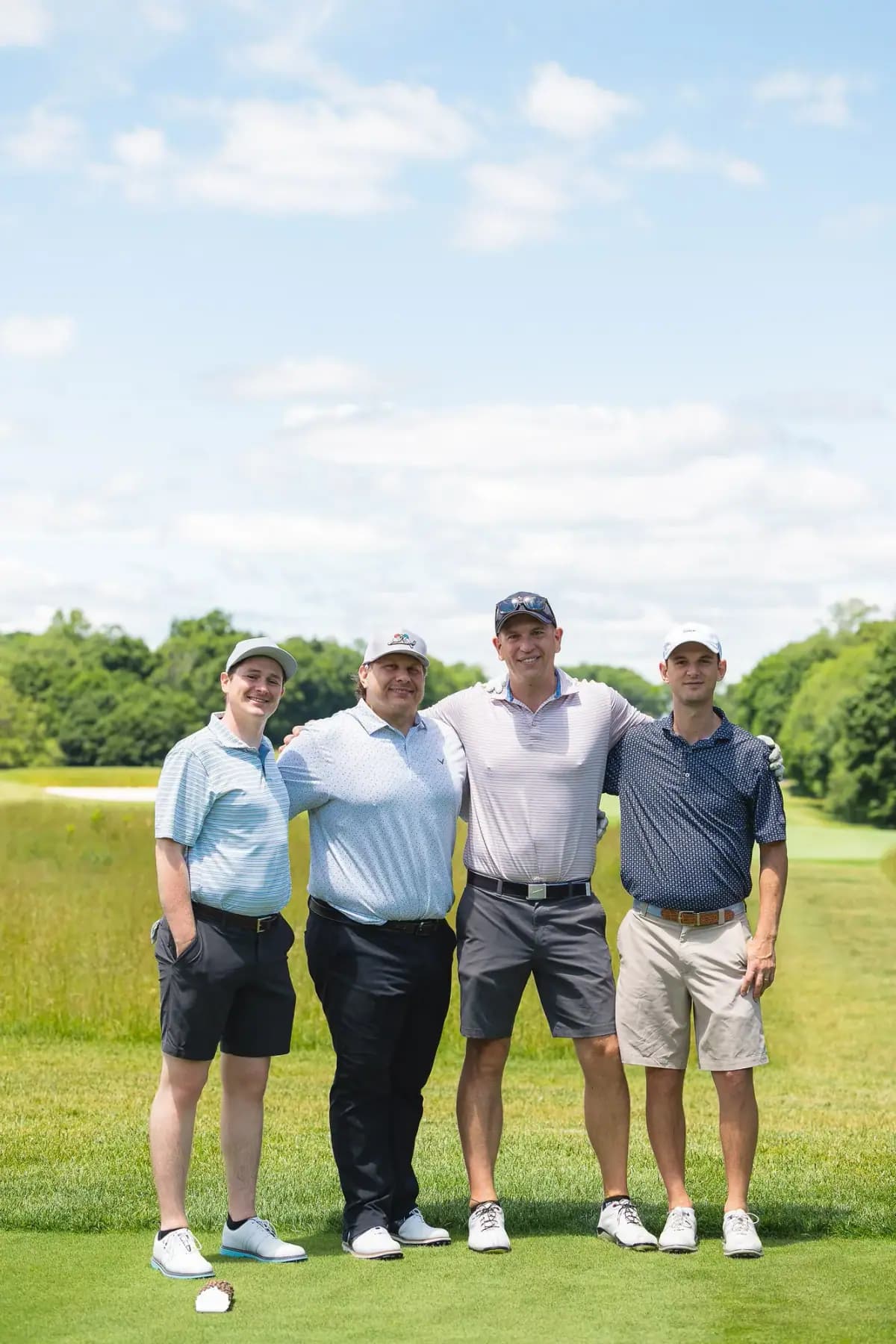 Four golfers posing on the course