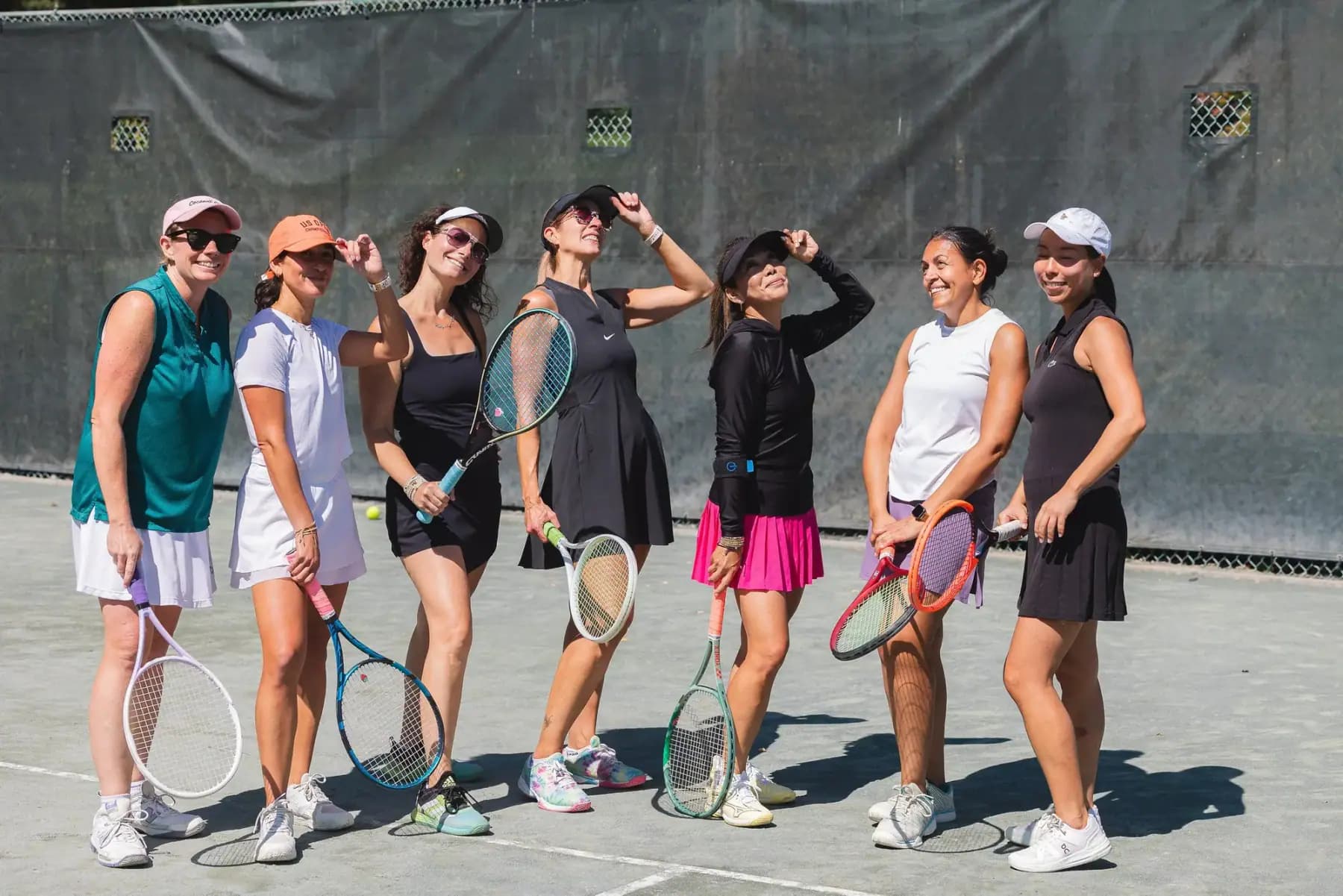Group of women players posing with rackets on a court