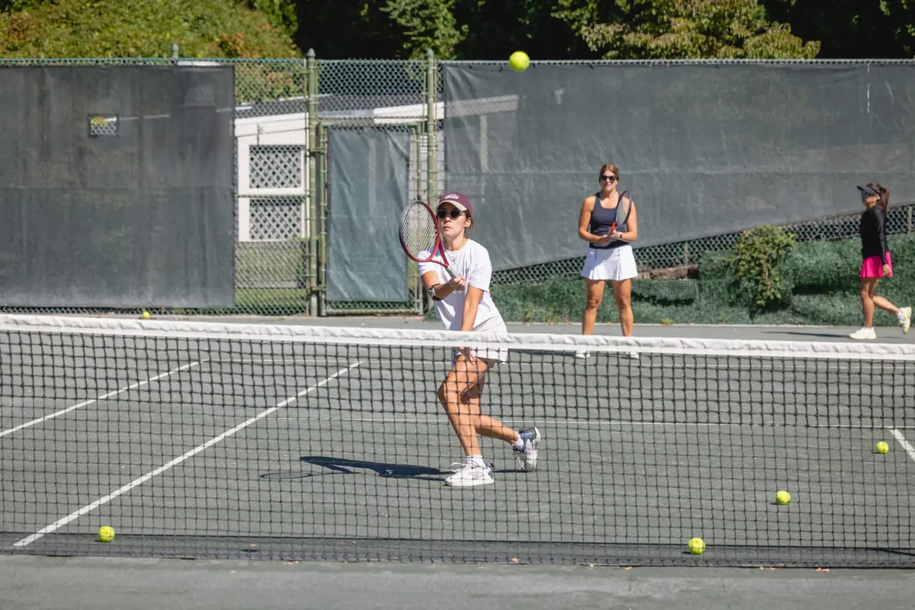 Doubles players rallying across the net on a clay court