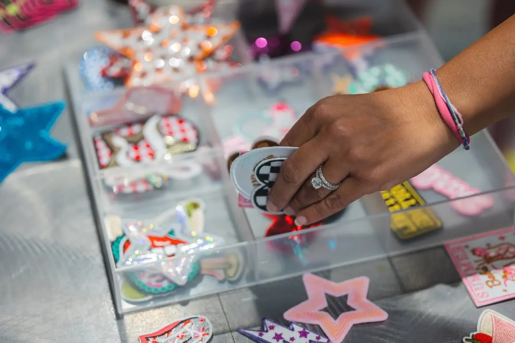Hand choosing a patch from a tray of decorative patches