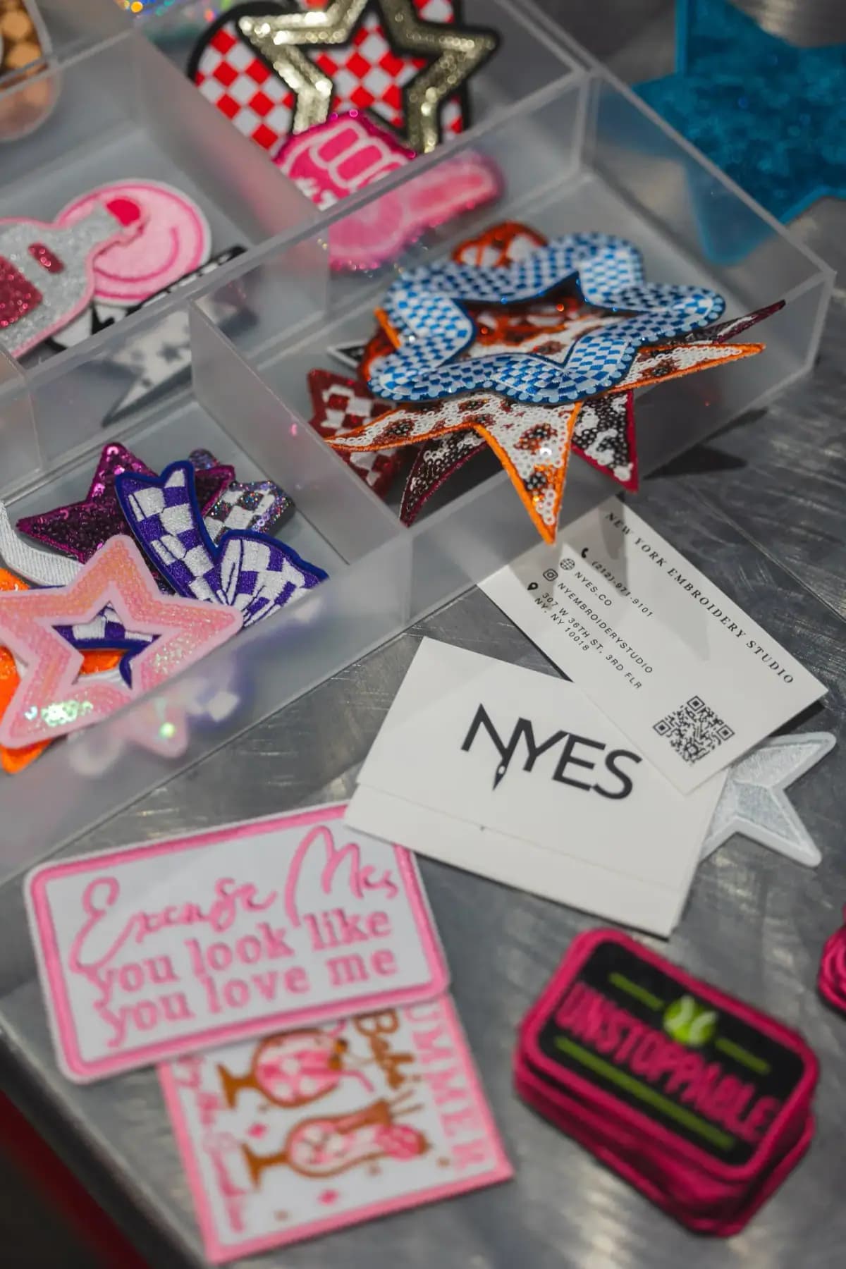 Tray of decorative patches, an NYES card and an UNSTOPPABLE patch